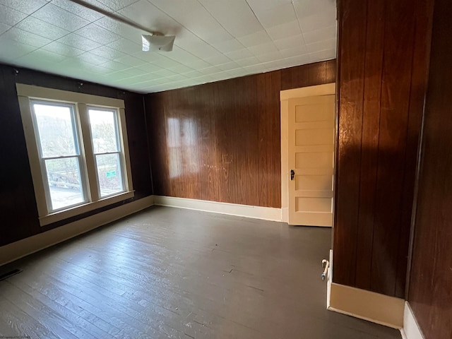 spare room with hardwood / wood-style floors and wooden walls