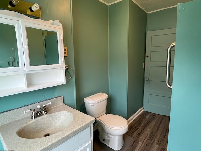 bathroom with hardwood / wood-style floors, vanity, toilet, and ornamental molding