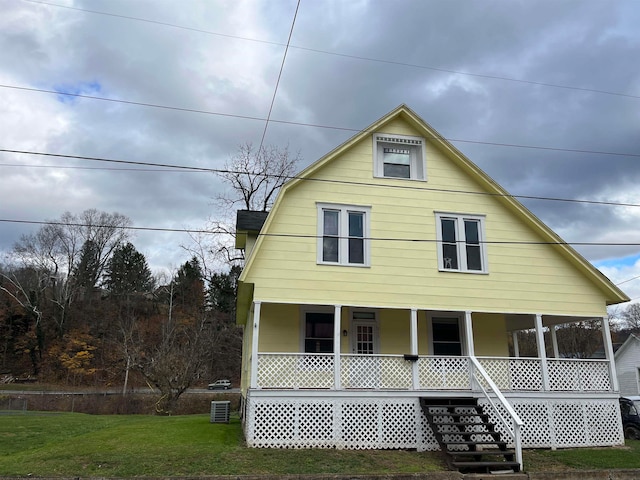 view of front of property featuring a front yard, a porch, and central AC unit