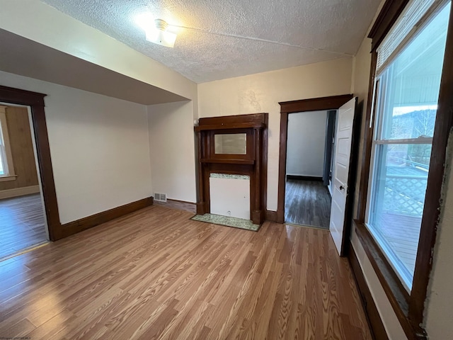 interior space with a textured ceiling and hardwood / wood-style flooring