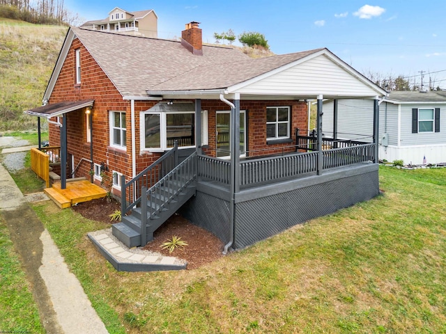 rear view of property featuring a yard and covered porch