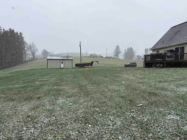 view of yard featuring a storage unit and a deck