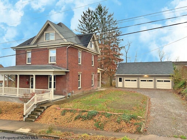 view of front of property with covered porch, a garage, an outdoor structure, and a front yard