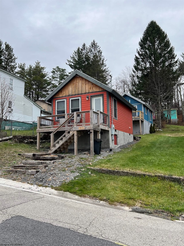 view of front of property featuring a wooden deck and a front lawn