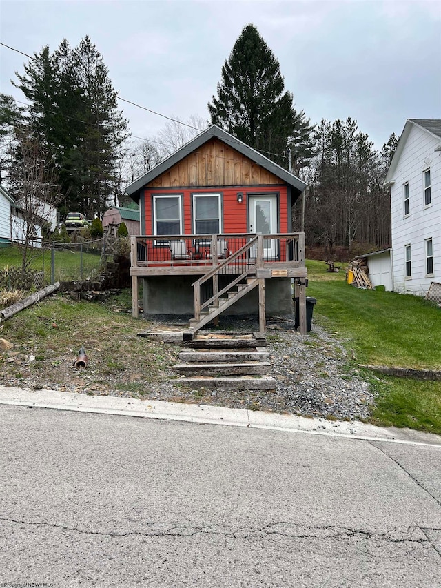 bungalow-style home featuring a wooden deck and a front lawn