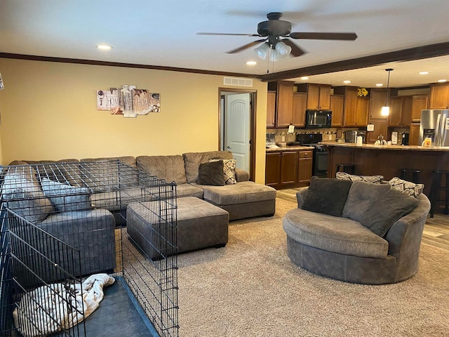 living room with ceiling fan, light colored carpet, and ornamental molding