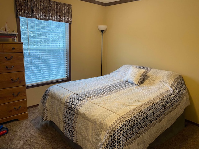 bedroom with dark colored carpet, crown molding, and multiple windows