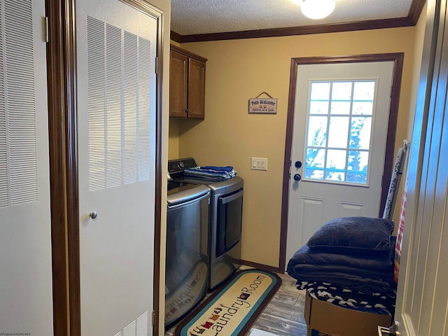 laundry area with cabinets, independent washer and dryer, crown molding, a textured ceiling, and light wood-type flooring