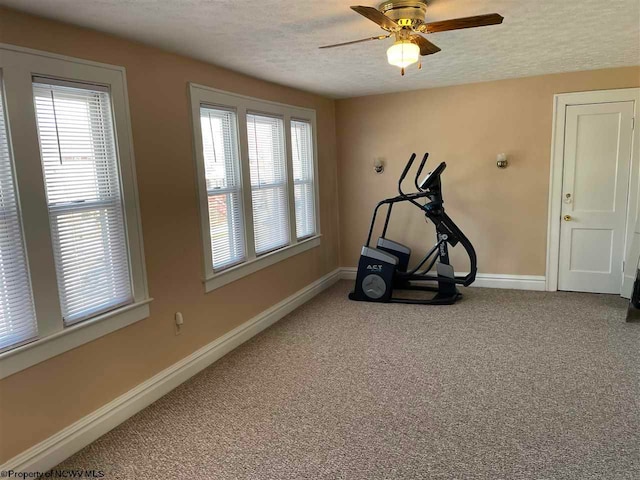 exercise area featuring carpet flooring, ceiling fan, and a textured ceiling