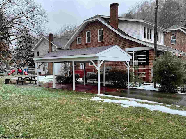 back of house featuring a carport and a yard