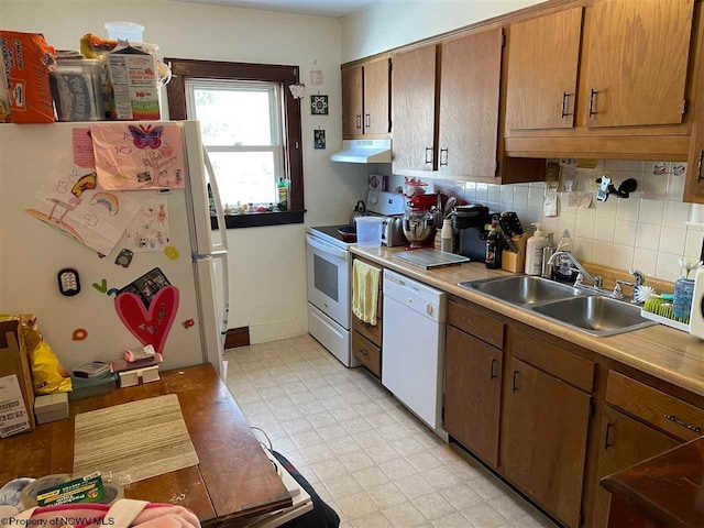 kitchen featuring decorative backsplash, sink, and white appliances