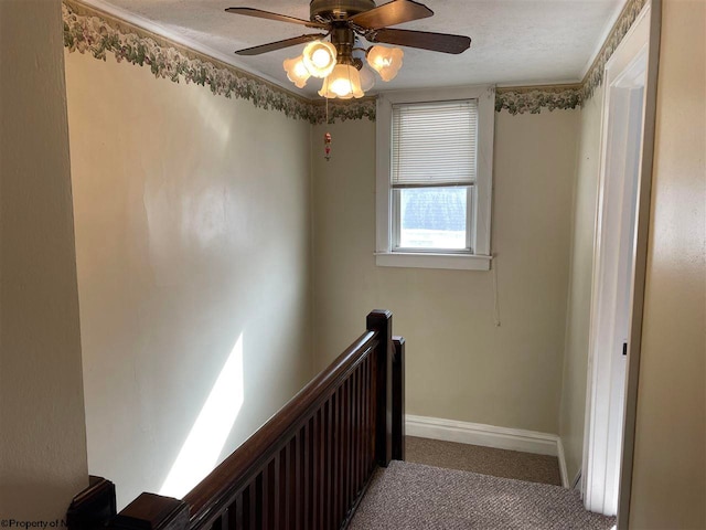 staircase featuring carpet flooring, ceiling fan, and a textured ceiling