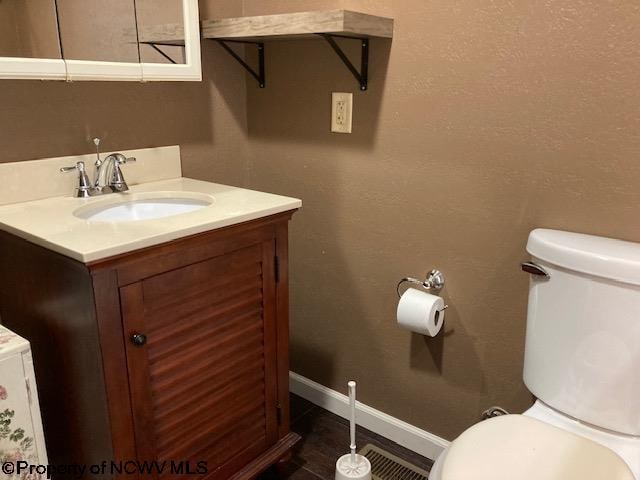 bathroom featuring vanity and toilet