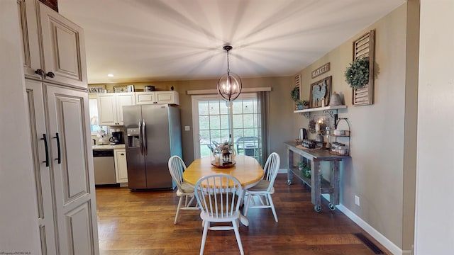 dining room with dark hardwood / wood-style floors and an inviting chandelier