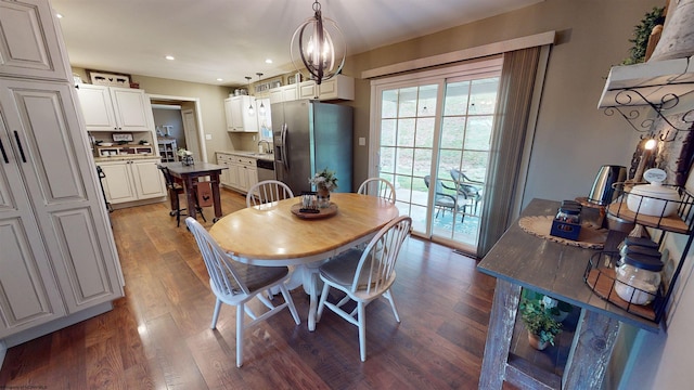 dining space featuring hardwood / wood-style flooring, an inviting chandelier, and sink