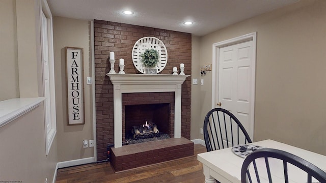 interior space featuring dark hardwood / wood-style flooring and a brick fireplace