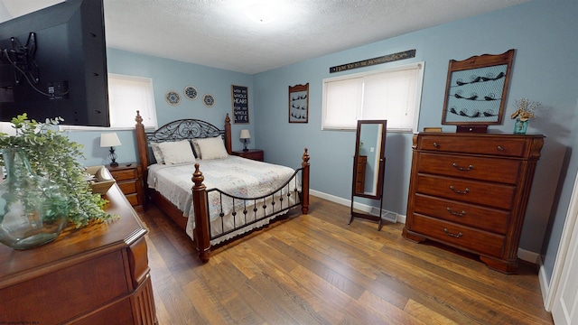 bedroom with dark hardwood / wood-style flooring and a textured ceiling