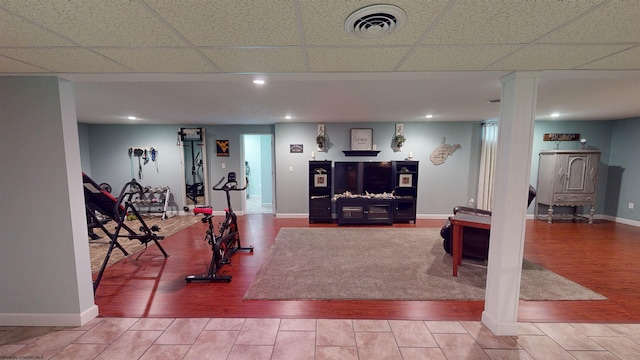 workout area with hardwood / wood-style flooring and a drop ceiling