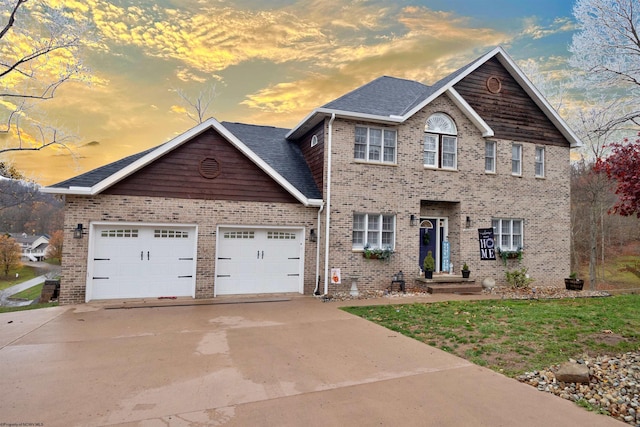 colonial inspired home featuring a lawn and a garage