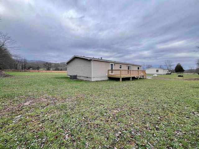 rear view of house featuring a yard, a deck, and cooling unit