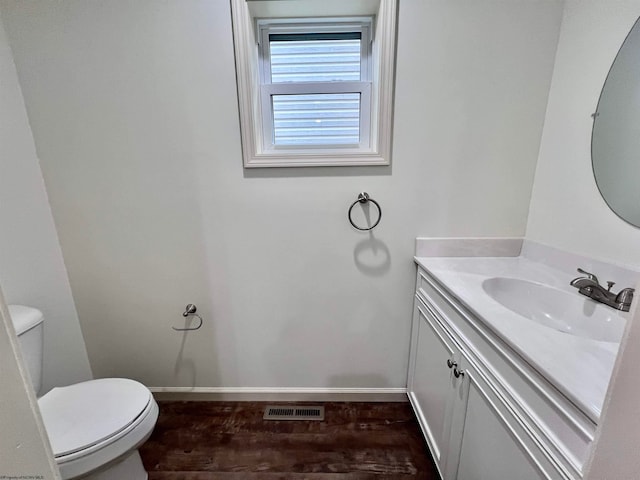 bathroom with hardwood / wood-style flooring, vanity, and toilet