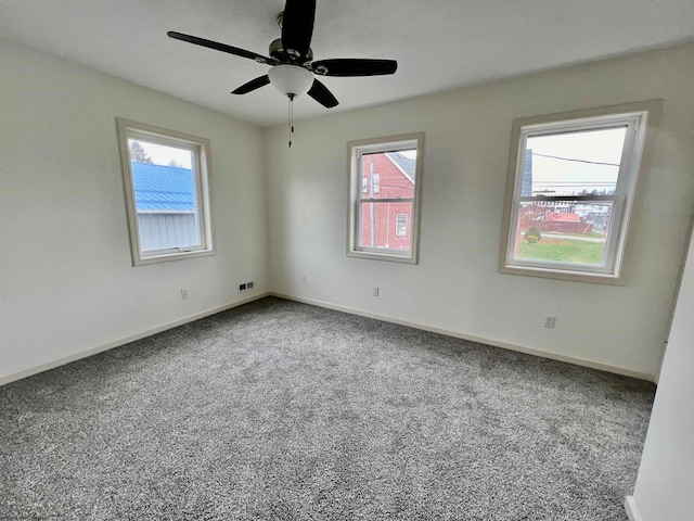 spare room with a wealth of natural light, carpet, and ceiling fan