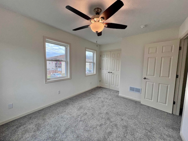 unfurnished bedroom featuring carpet flooring, ceiling fan, a closet, and a textured ceiling