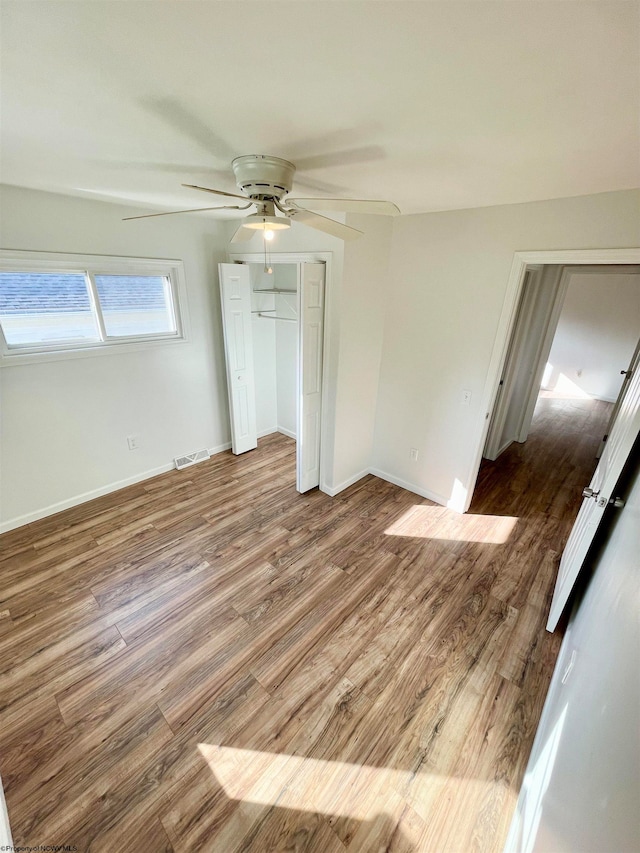 unfurnished bedroom featuring wood-type flooring, a closet, and ceiling fan