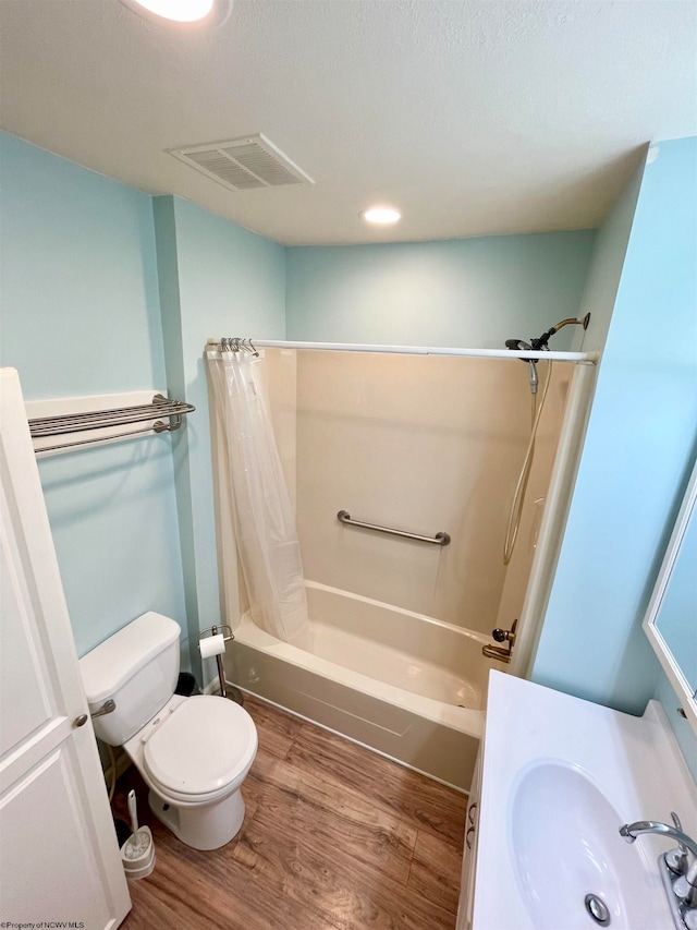 full bathroom featuring wood-type flooring, toilet, shower / bath combo with shower curtain, and sink