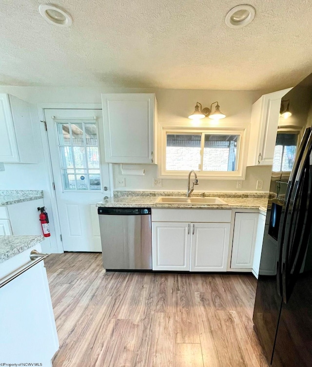 kitchen featuring black refrigerator with ice dispenser, sink, light hardwood / wood-style flooring, dishwasher, and white cabinetry