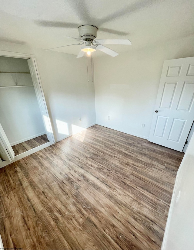 unfurnished bedroom with hardwood / wood-style floors, ceiling fan, and a closet