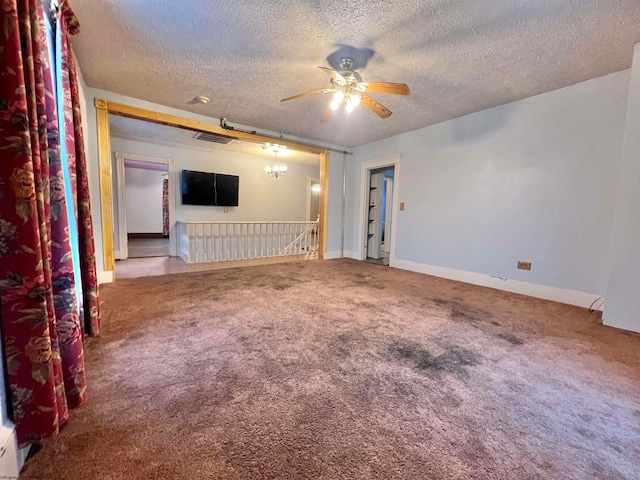 unfurnished room with carpet flooring, ceiling fan with notable chandelier, and a textured ceiling