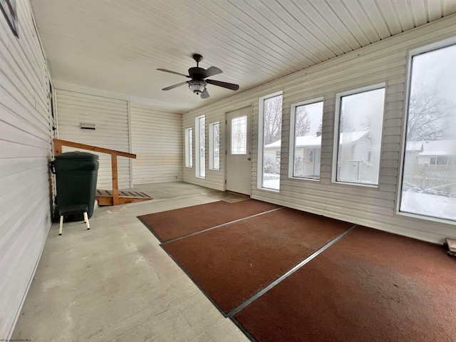 unfurnished sunroom featuring ceiling fan