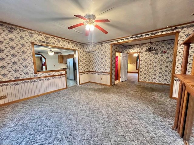 spare room featuring carpet, crown molding, and ceiling fan