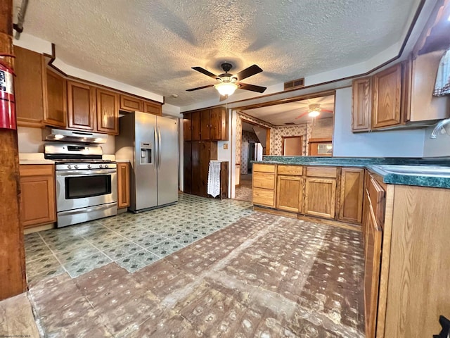 kitchen featuring appliances with stainless steel finishes, a textured ceiling, ceiling fan, and sink