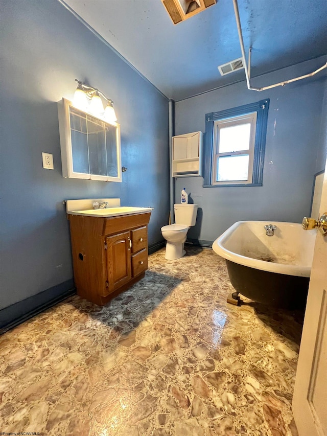 bathroom with vanity, a bath, and toilet