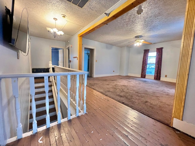 unfurnished room with hardwood / wood-style flooring, ceiling fan with notable chandelier, and a textured ceiling