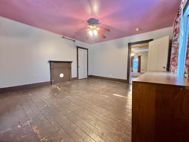 unfurnished living room with dark hardwood / wood-style flooring and ceiling fan