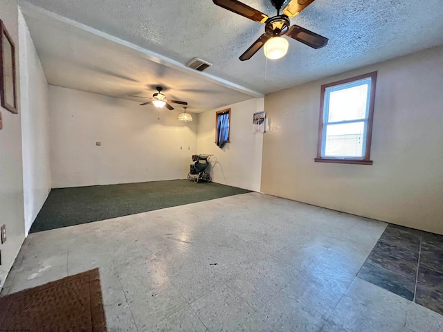 empty room featuring ceiling fan and a textured ceiling