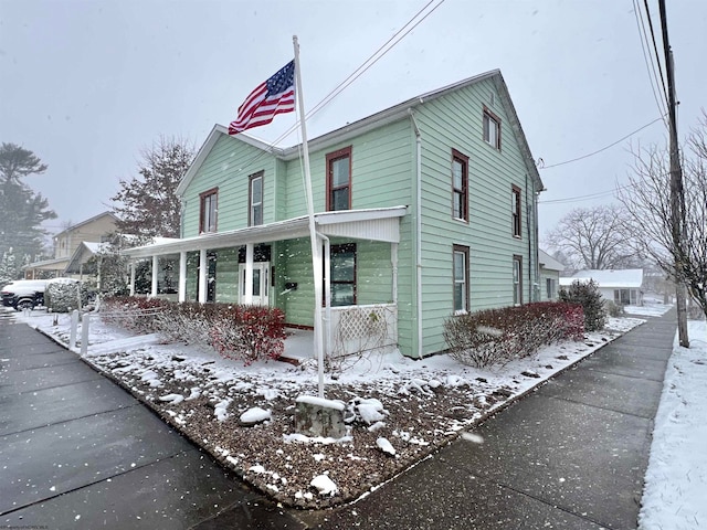 snow covered property with a porch