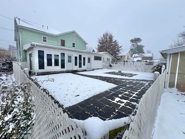 view of snow covered rear of property