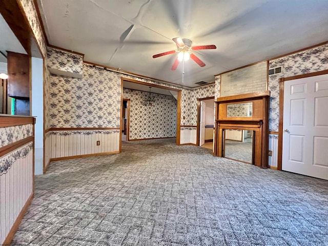 unfurnished living room with carpet, ceiling fan, and ornamental molding