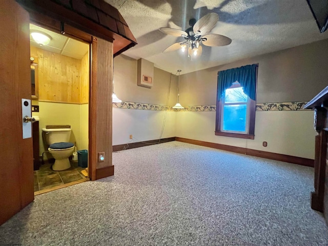 interior space featuring carpet, a textured ceiling, ensuite bathroom, and ceiling fan