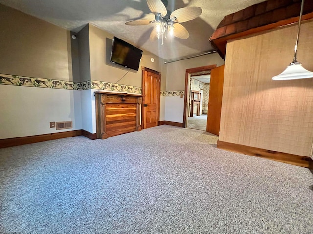 empty room featuring carpet flooring, ceiling fan, and a textured ceiling