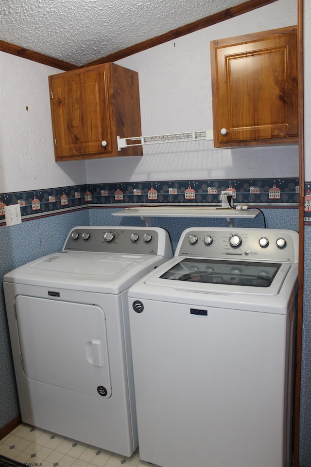 laundry area with cabinets, independent washer and dryer, a textured ceiling, and crown molding