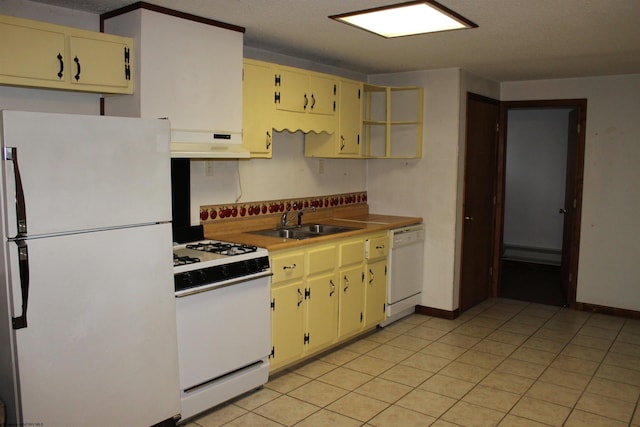 kitchen featuring white appliances, cream cabinets, a baseboard heating unit, sink, and light tile patterned floors