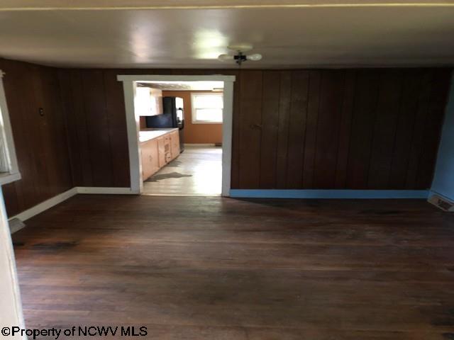 empty room with dark hardwood / wood-style floors and wood walls