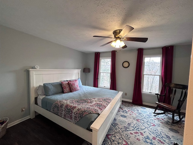 bedroom featuring hardwood / wood-style flooring, ceiling fan, a textured ceiling, and multiple windows