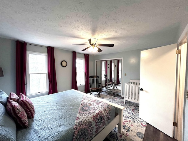 bedroom with ceiling fan, hardwood / wood-style floors, and a textured ceiling