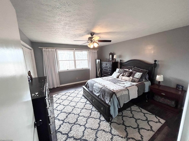 bedroom with ceiling fan, hardwood / wood-style floors, and a textured ceiling